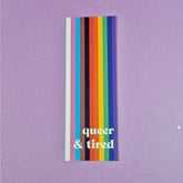 Bookmark with progressive pride flag with text that reads 'queer & tired'.