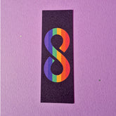 Bookmark with pride flag inside an infinity symbol. Front side of bookmark