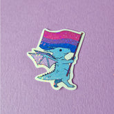 A sticker that has a cute dragon carrying a bisexual pride flag. This pride sticker makes a great gift