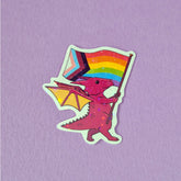 A sticker that has a cute dragon carrying a progressive pride flag. This pride sticker makes a great gift
