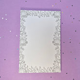 Memo pad with decorative border with a variety of sex toys on it; rabbit, dildo, anal beads, butt plug, vibrator and more