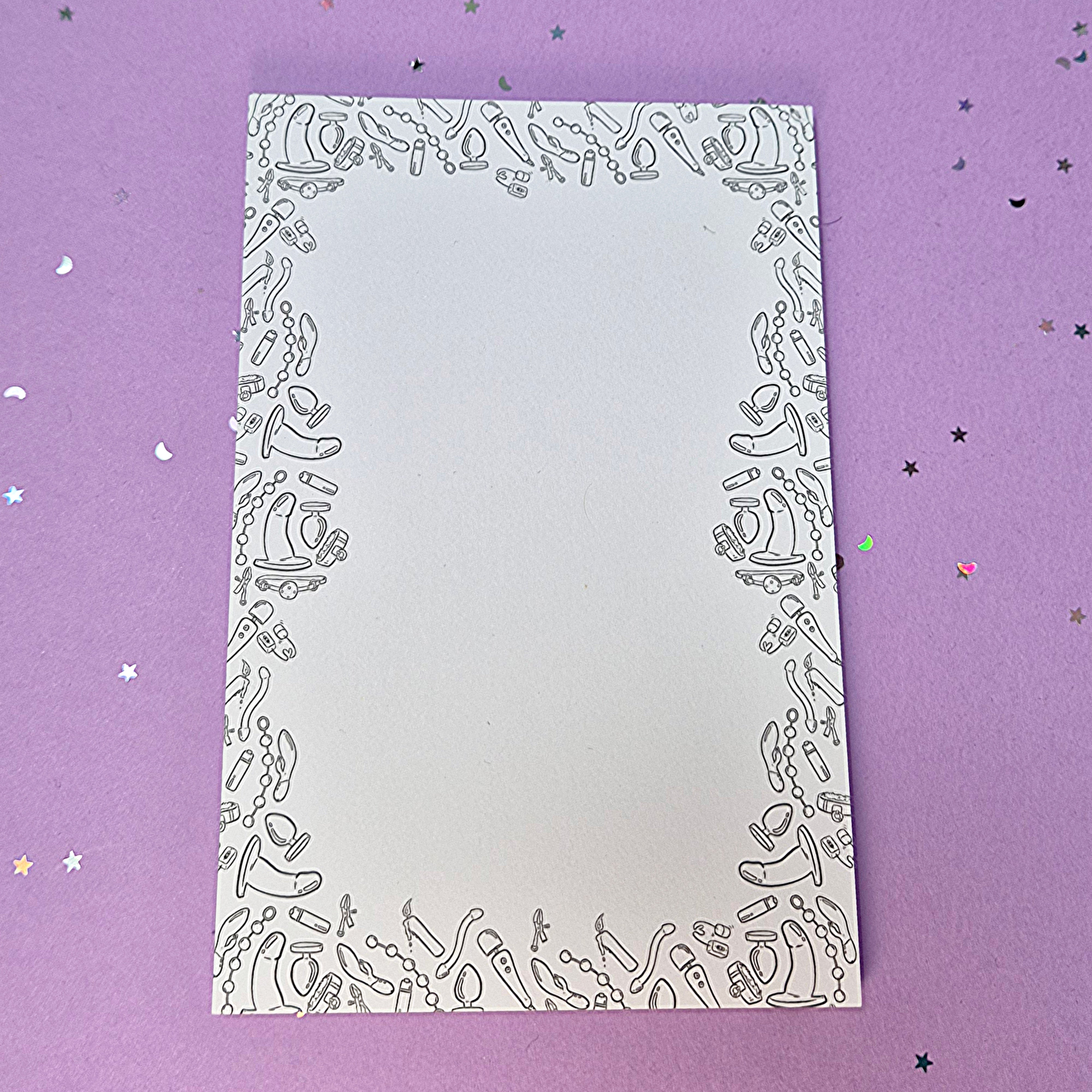 Memo pad with decorative border with a variety of sex toys on it; rabbit, dildo, anal beads, butt plug, vibrator and more