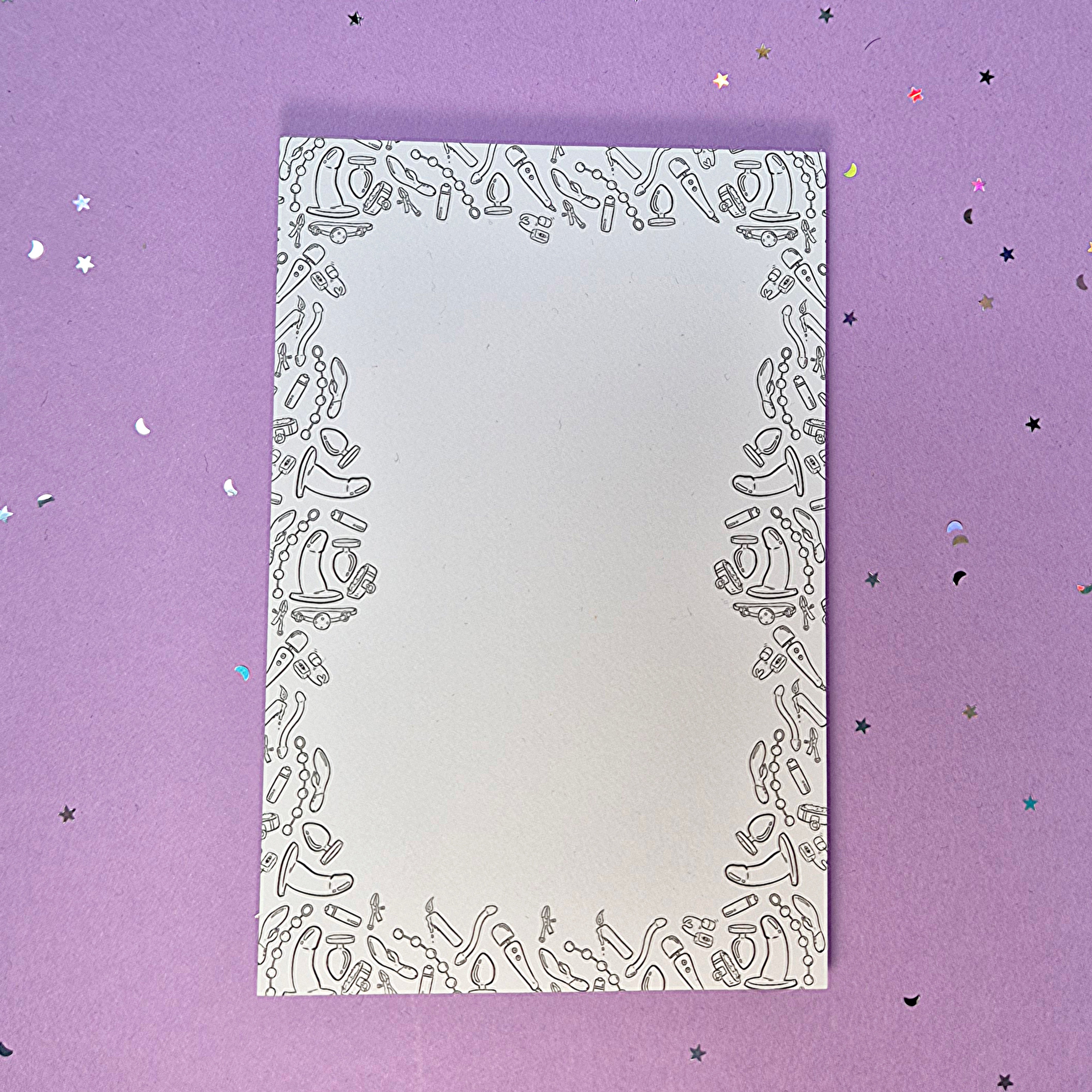 Memo pad with decorative border with a variety of sex toys on it; rabbit, dildo, anal beads, butt plug, vibrator and more