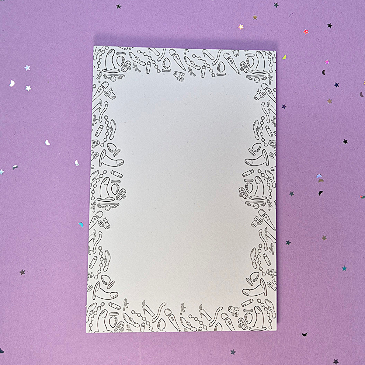 Memo pad with decorative border with a variety of sex toys on it; rabbit, dildo, anal beads, butt plug, vibrator and more
